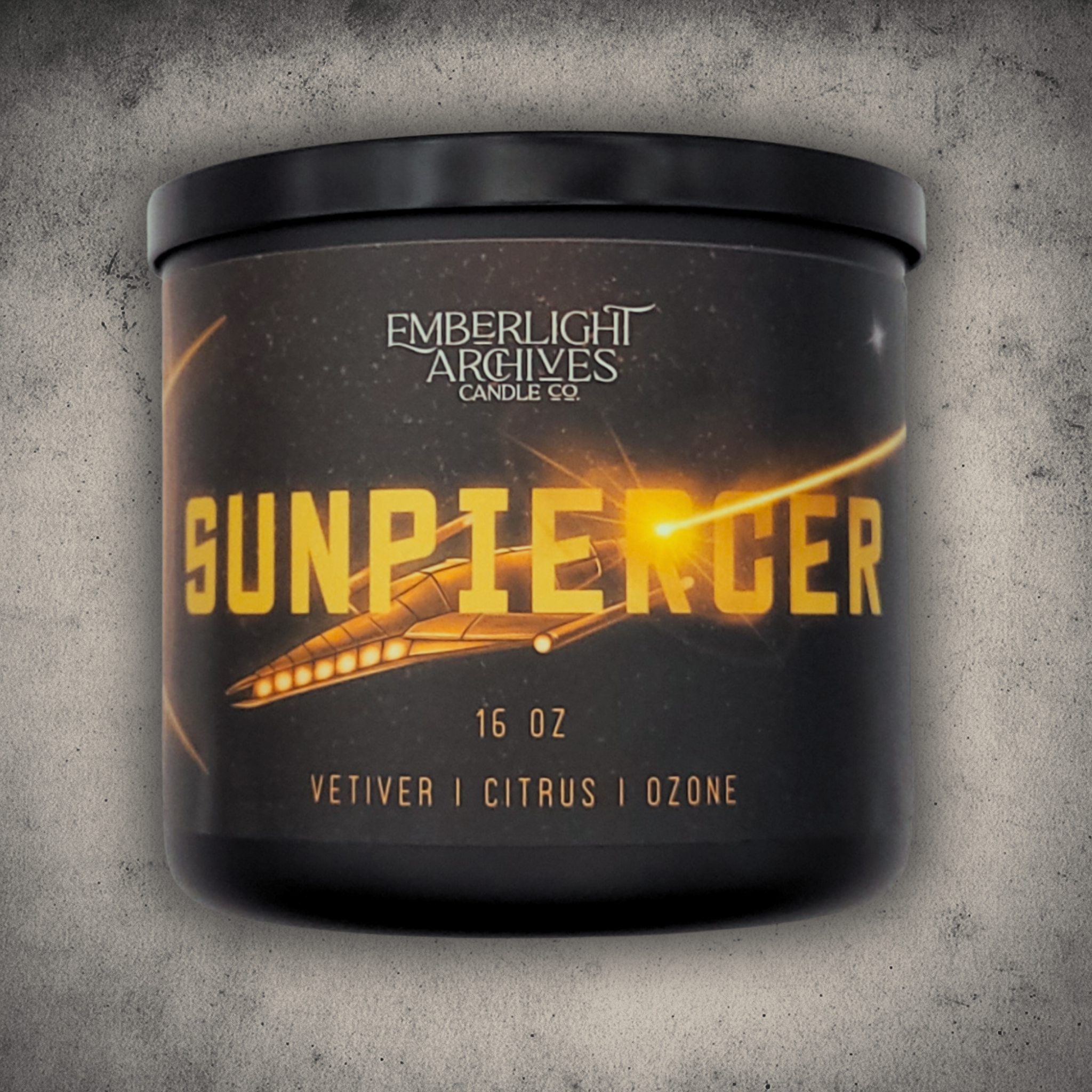 Emberlight Archives Sunpiercer candle in a 16oz black glass jar with illustrated spaceship label against a gray stone background, Citrus scent.